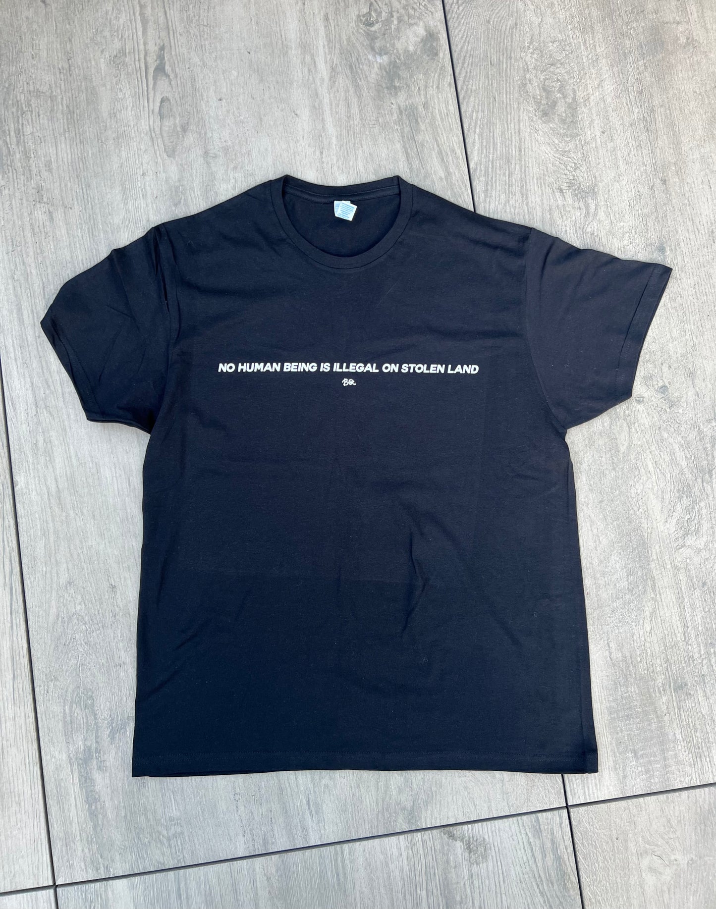 “No Human Being is Illegal on Stolen Land” tee